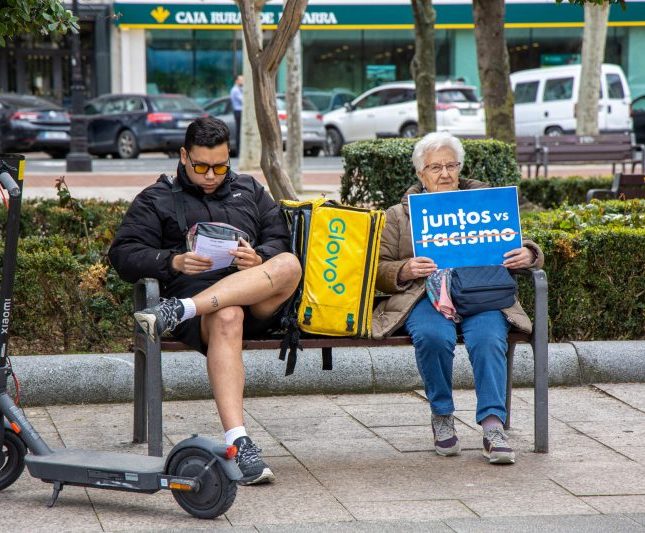 mujer mayor joven glovo cartel juntos vs racismo (tachado)